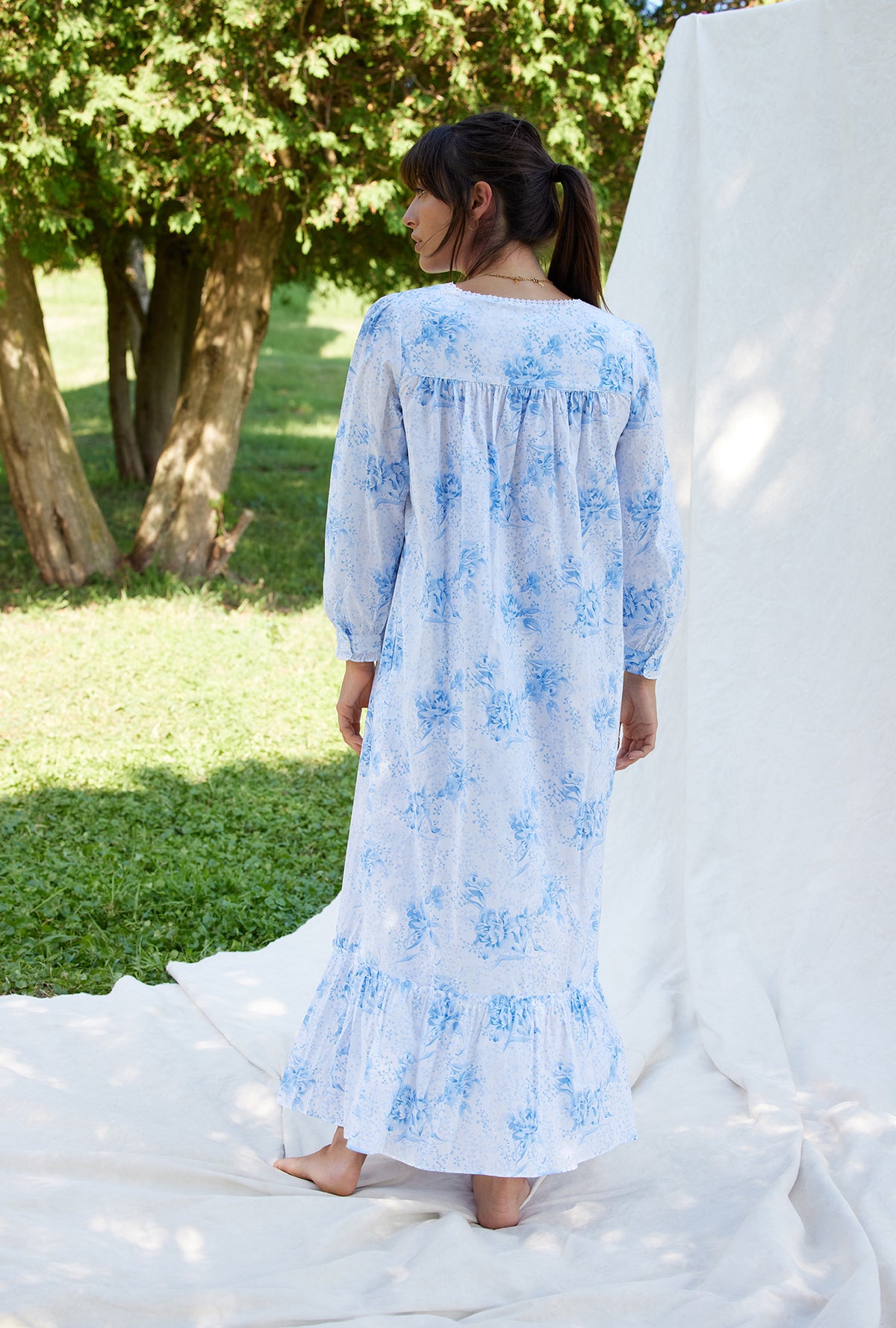 A lady wearing a pastoral floral long sleeve button front cotton robe.