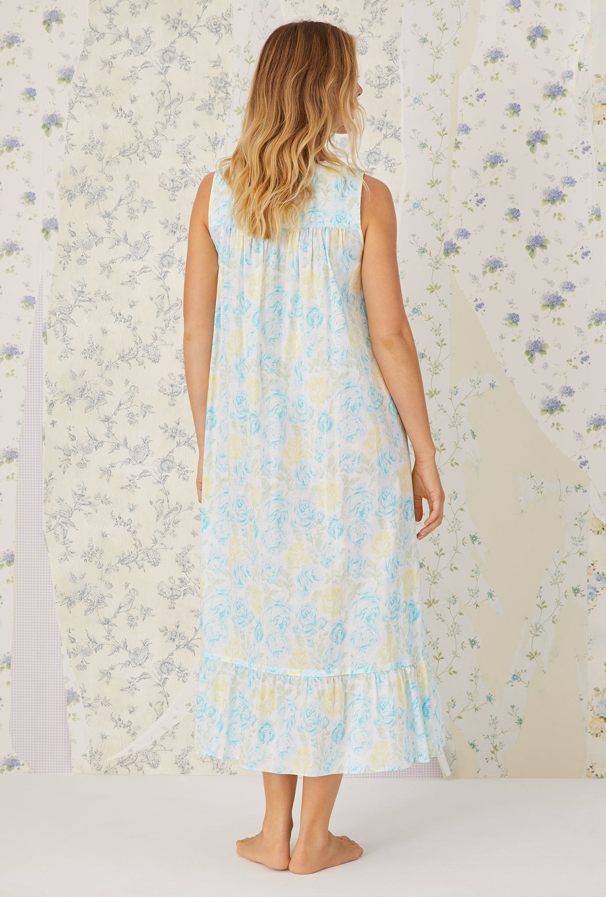A lady wearing aqua sleeveless cotton lawn nightgown with floral pattern.