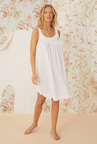 A lady wearing white sleeveless nuage short chemise.