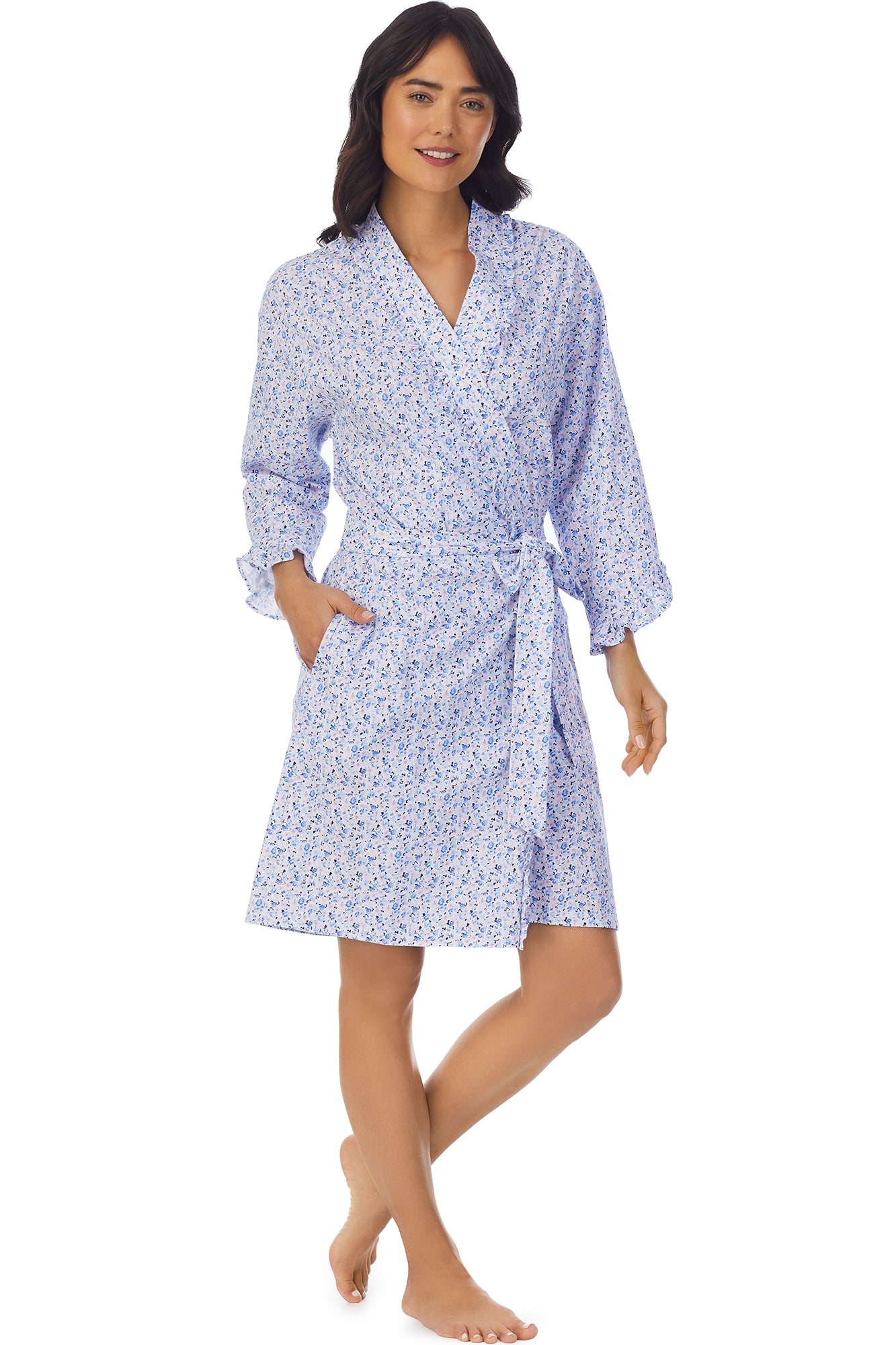 A lady wearing a white long sleeve shortie wrap with blue floral pattern.