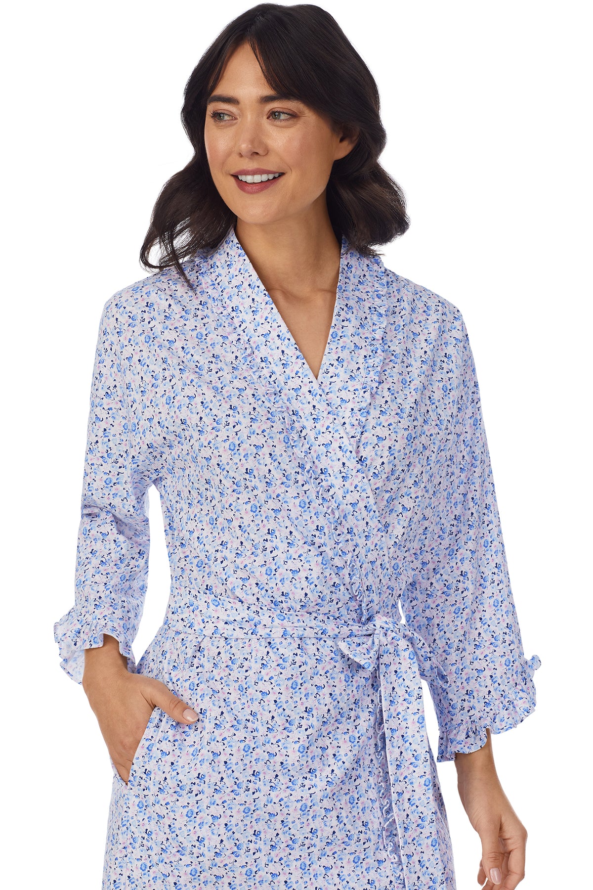 A lady wearing a white long sleeve shortie wrap with blue floral pattern.