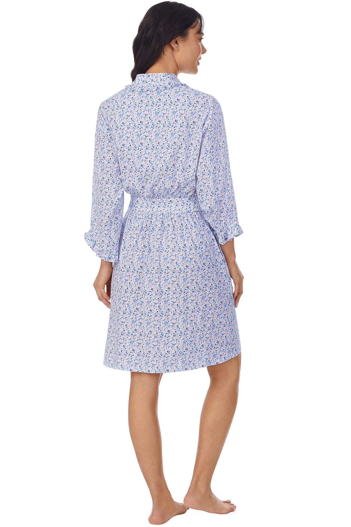 A lady wearing a white long sleeve shortie wrap with blue floral pattern.