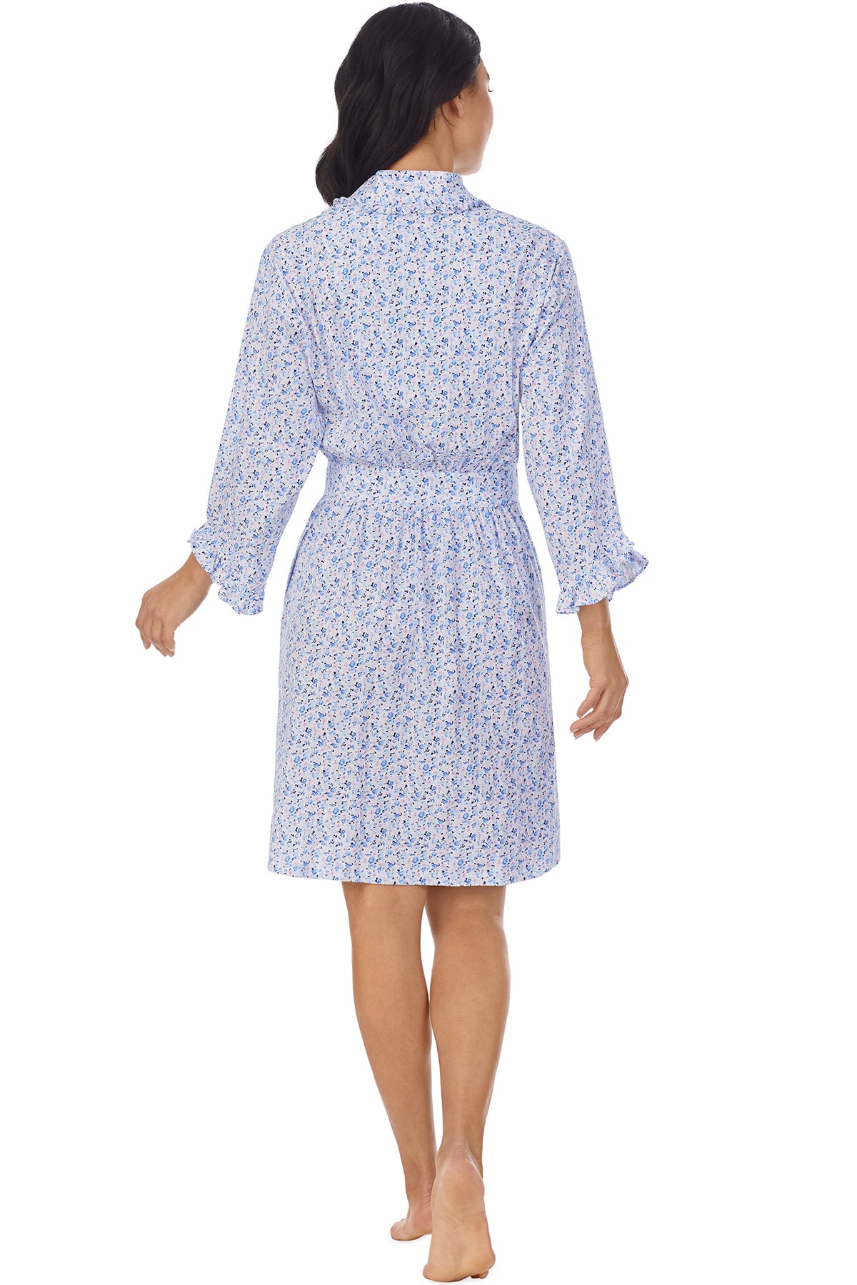 A lady wearing a white long sleeve shortie wrap with blue floral pattern.