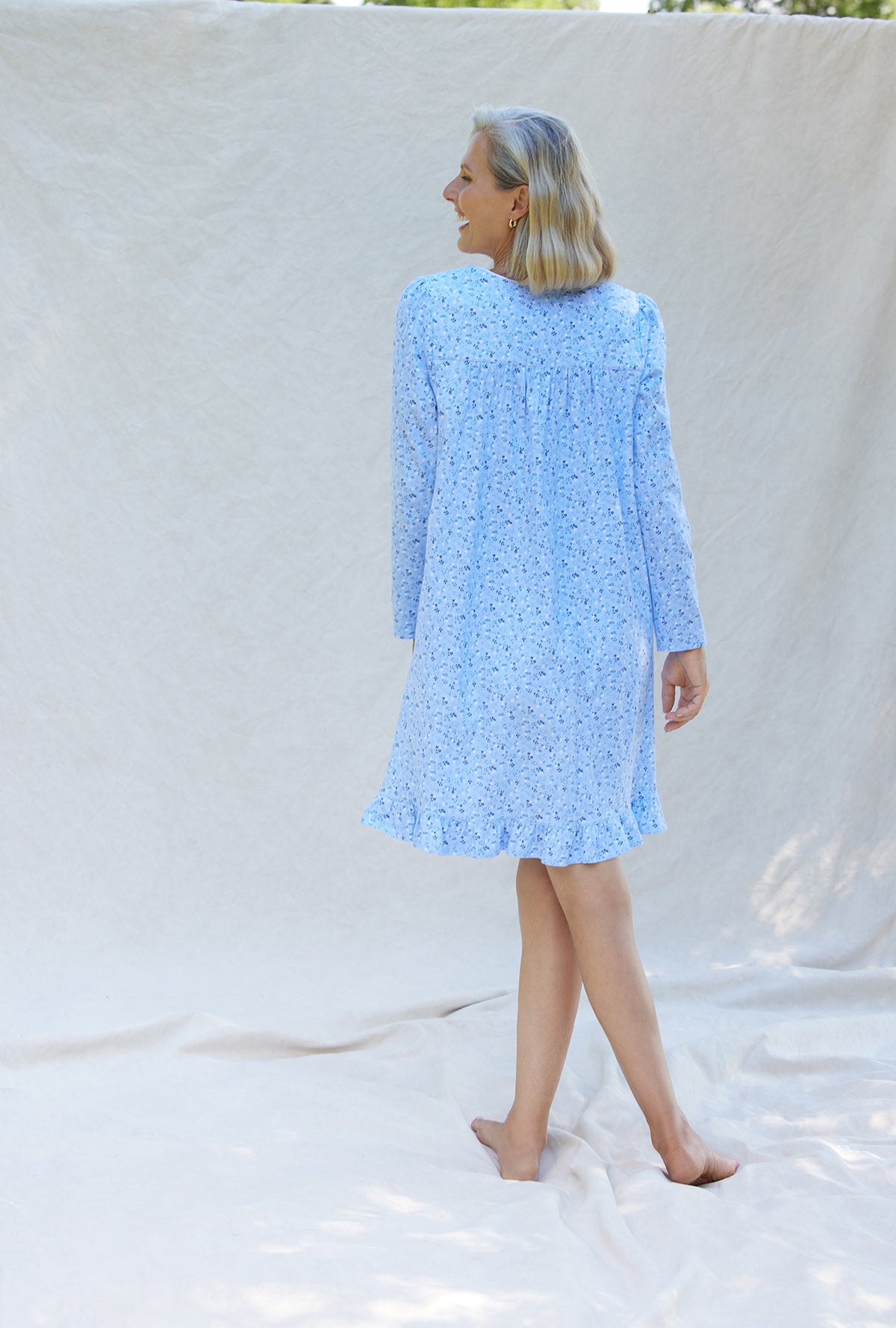 A lady wearing a blue denim floral long sleeve cotton knit short nightgown.