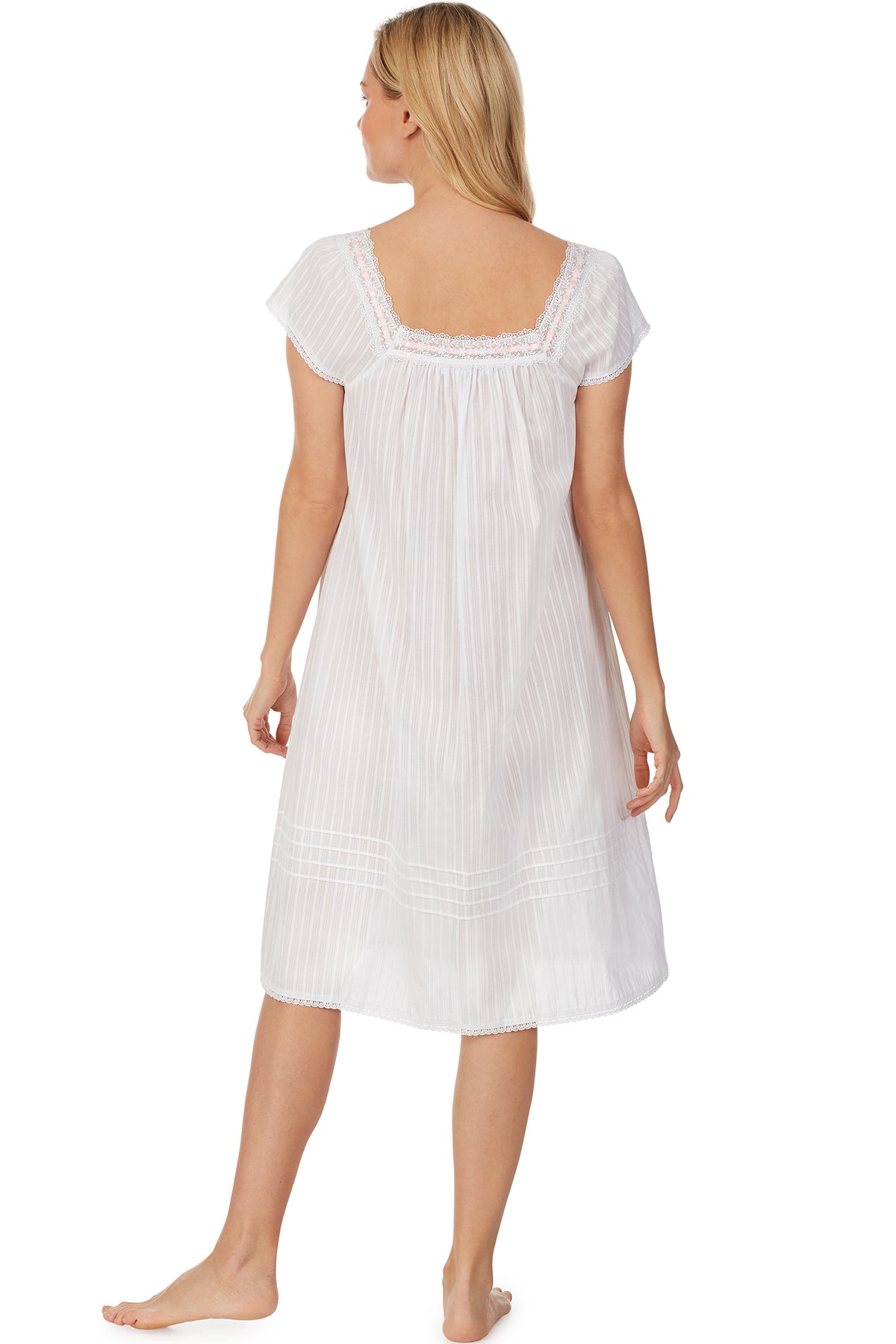 A lady wearing cap sleeve white waltz nightgown with stripe textures