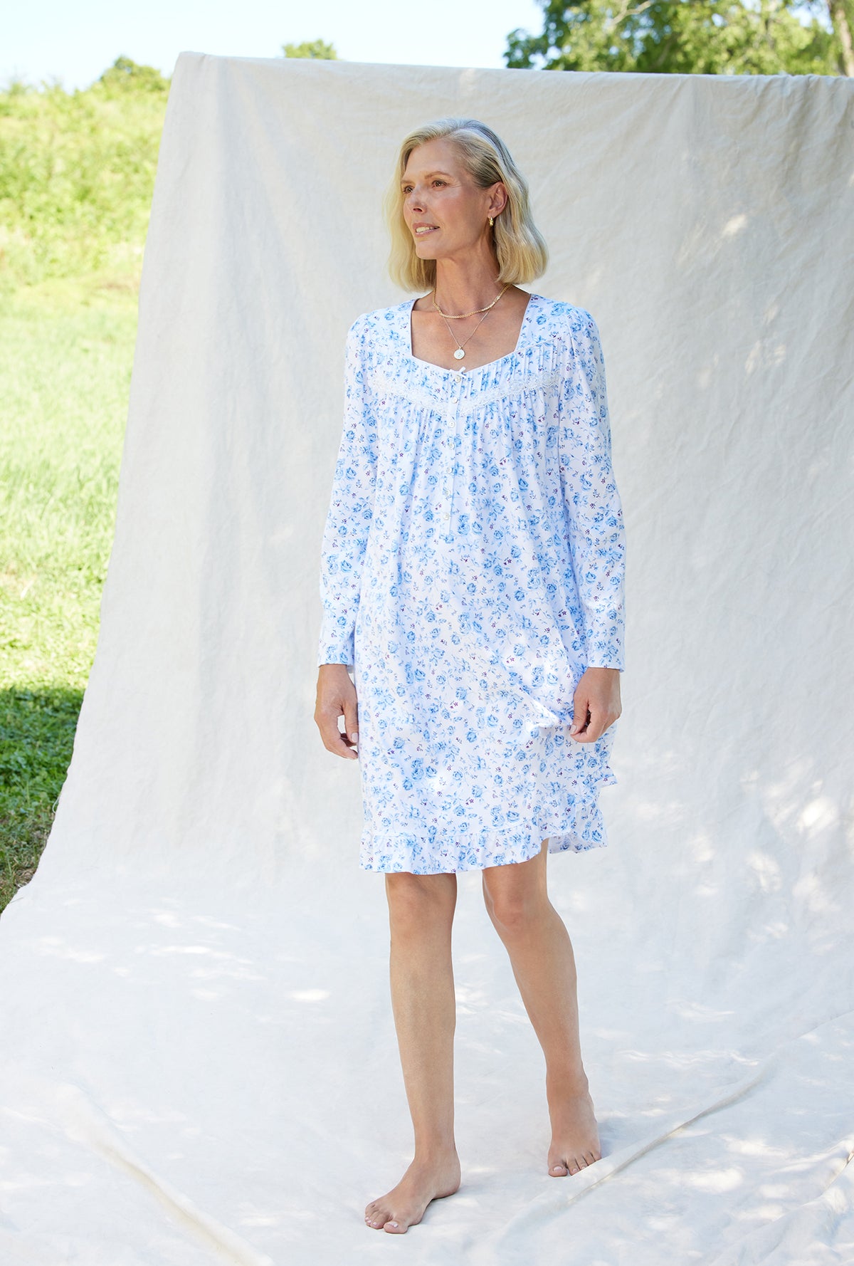 A lady wearing a rose garden floral long sleeve cotton knit short nightgown.