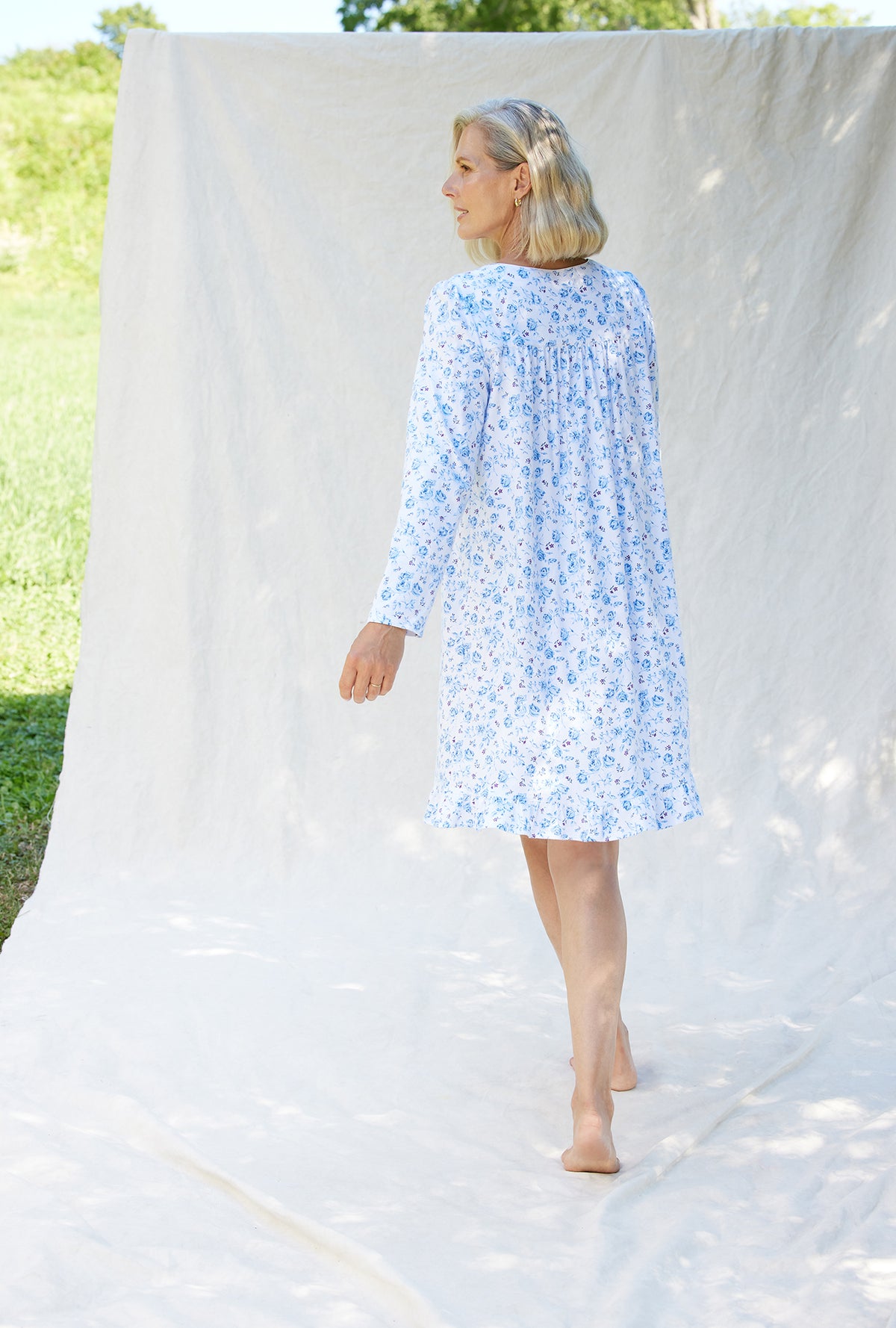 A lady wearing a rose garden floral long sleeve cotton knit short nightgown.