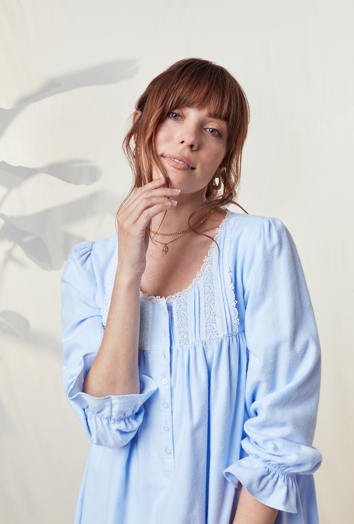 A lady wearing a heavenly blue long sleeve rayon lightweight flannel waltz nightgown.