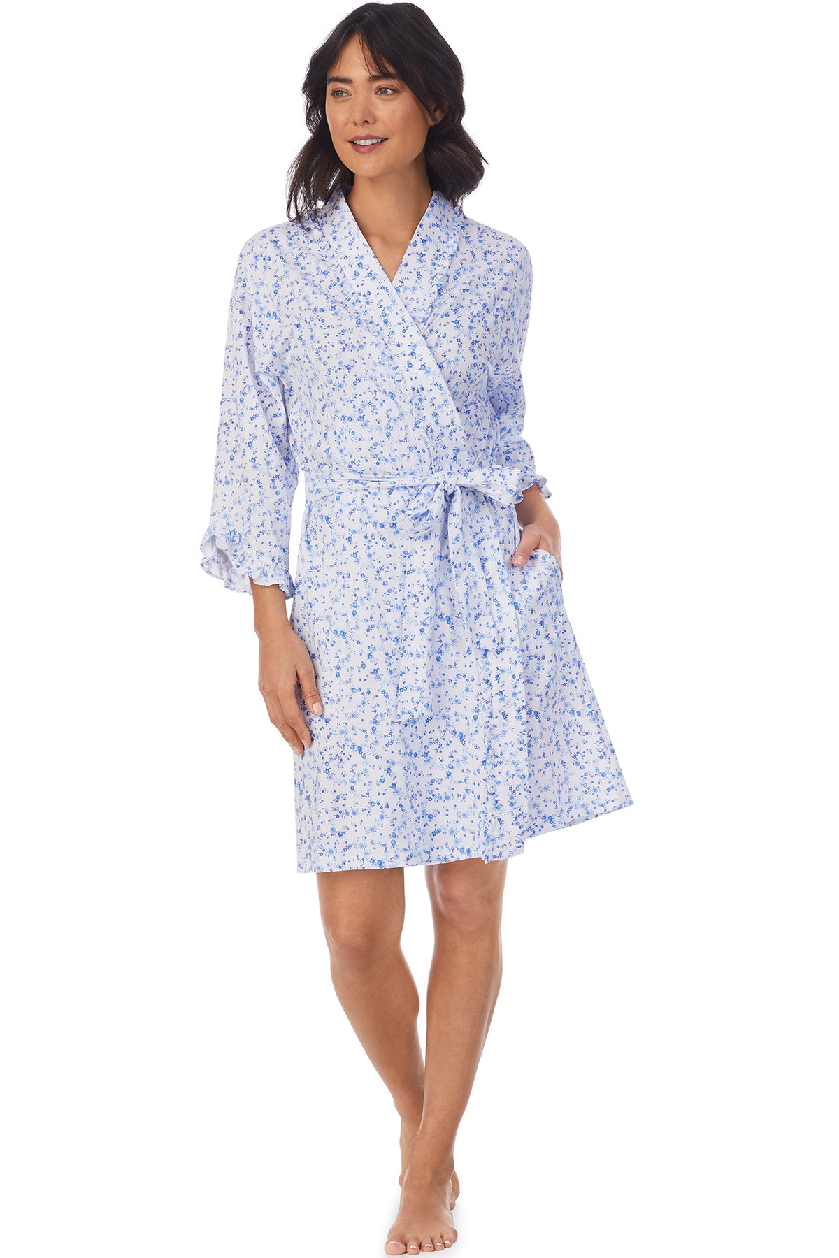 A lady wearing a white long sleeve shortie wrap with blue floral pattern.