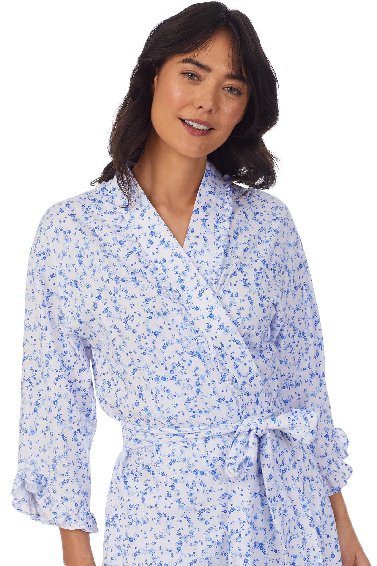 A lady wearing a white long sleeve shortie wrap with blue floral pattern.