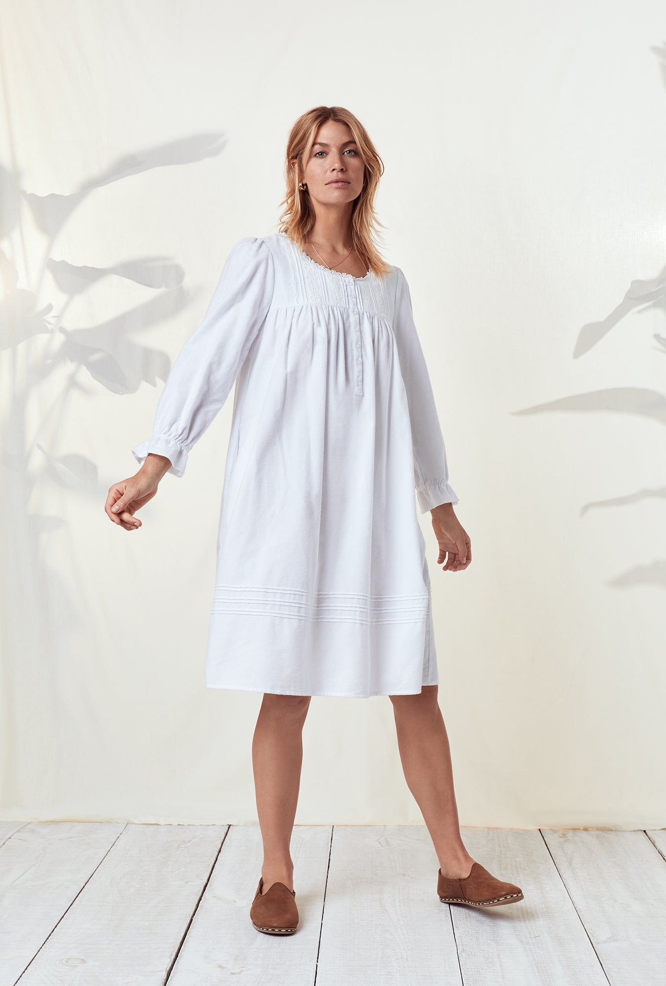 A lady wearing a white long sleeve rayon lightweight flannel waltz nightgown.