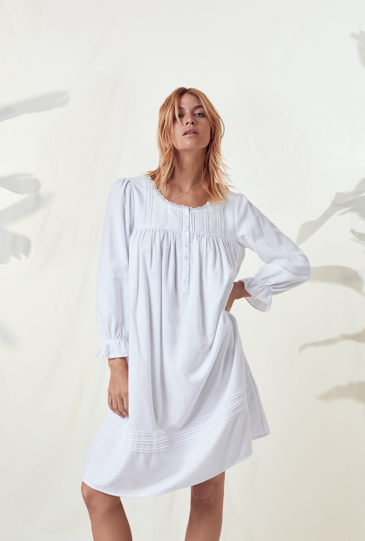 A lady wearing a white long sleeve rayon lightweight flannel waltz nightgown.