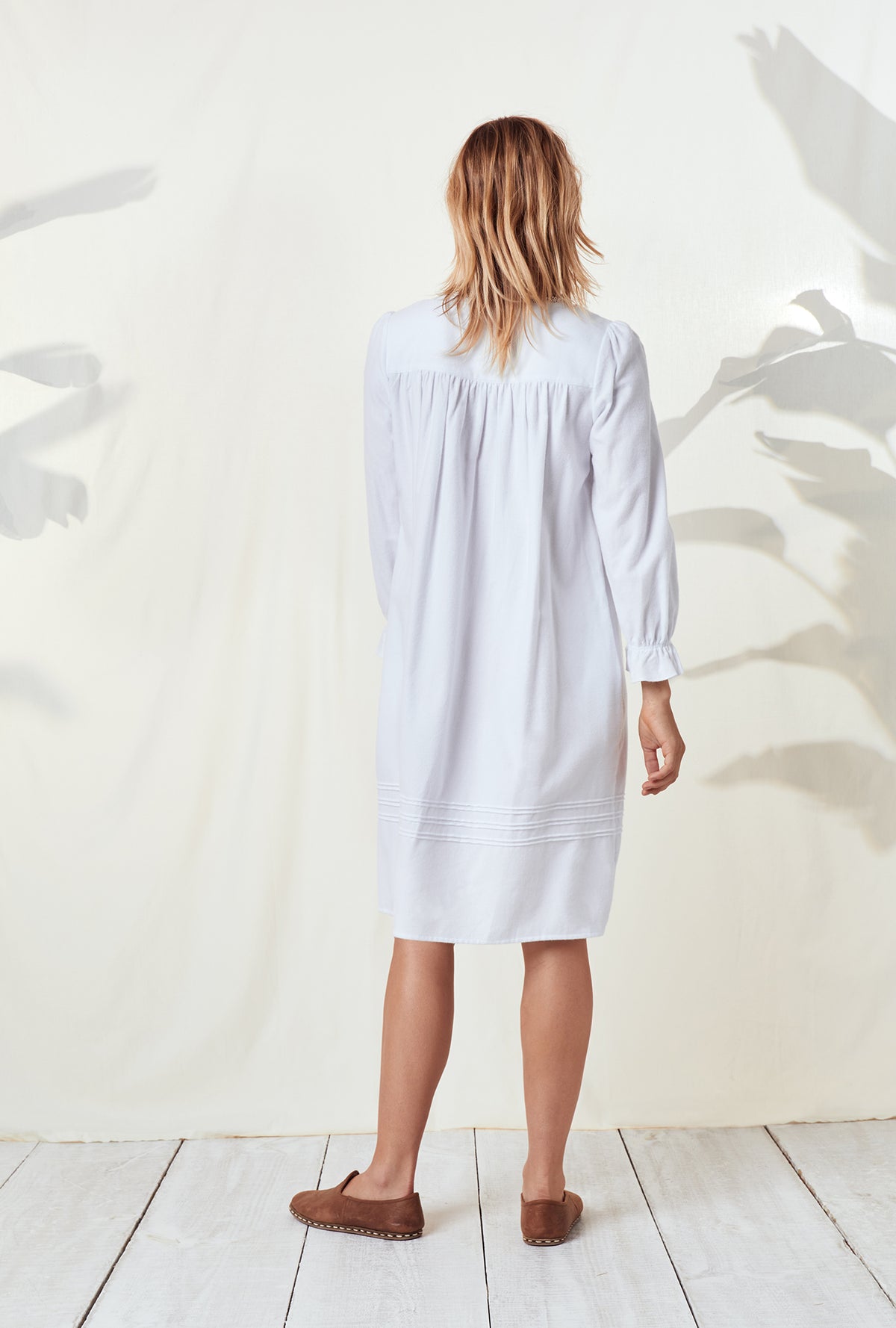 A lady wearing a white long sleeve rayon lightweight flannel waltz nightgown.