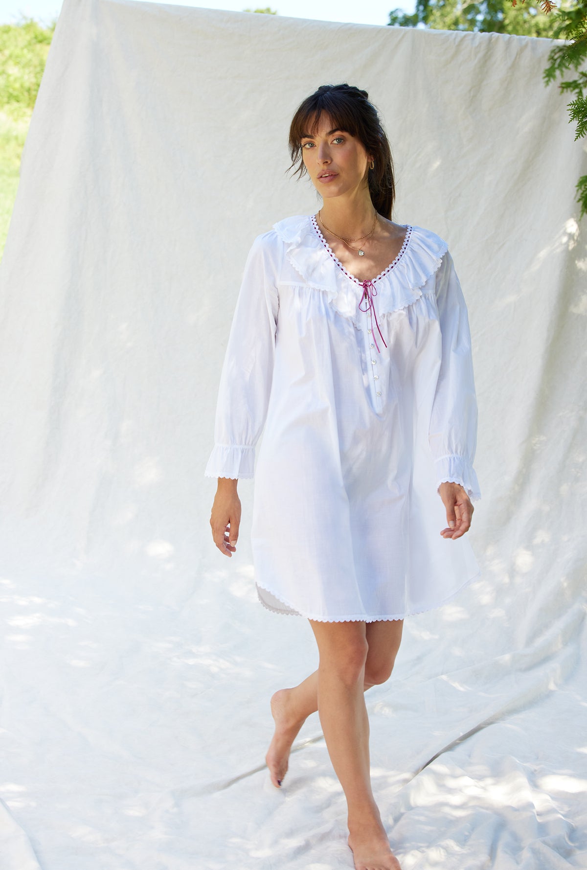 A lady wearing a white long sleeve clara poet nightshirt.