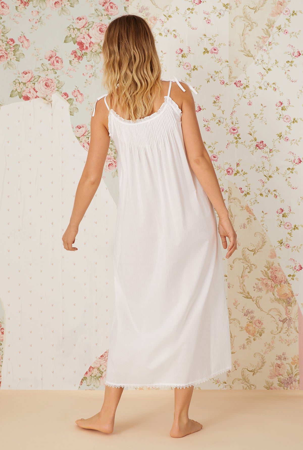 A lady wearing white sleeveless cotton nightgown with the erica.