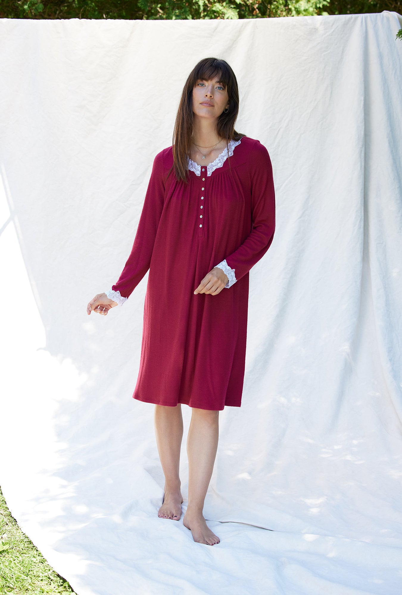 A lady wearing a crimson long sleeve short nightgown.