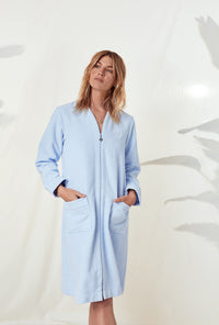 A lady wearing a terry blue long sleeve spa soft zip robe