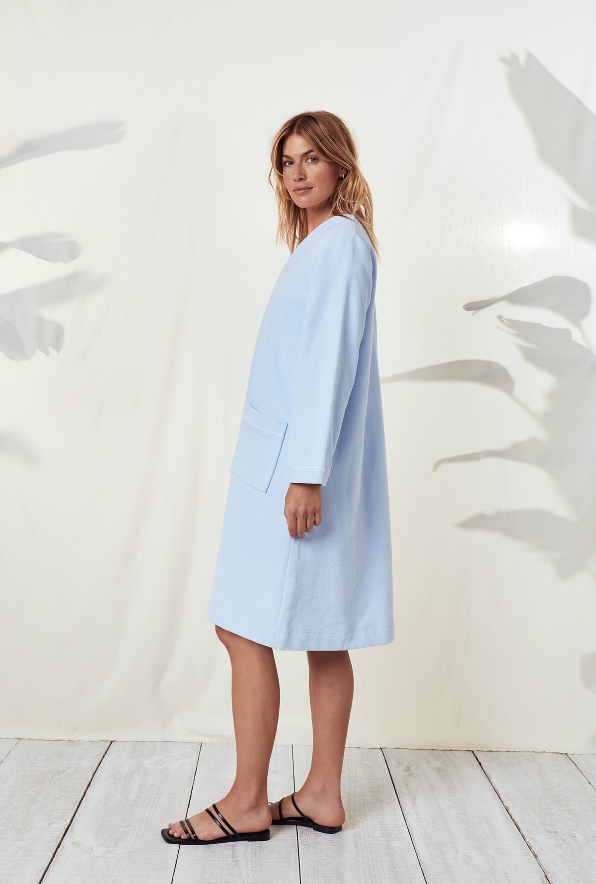 A lady wearing a terry blue long sleeve spa soft zip robe