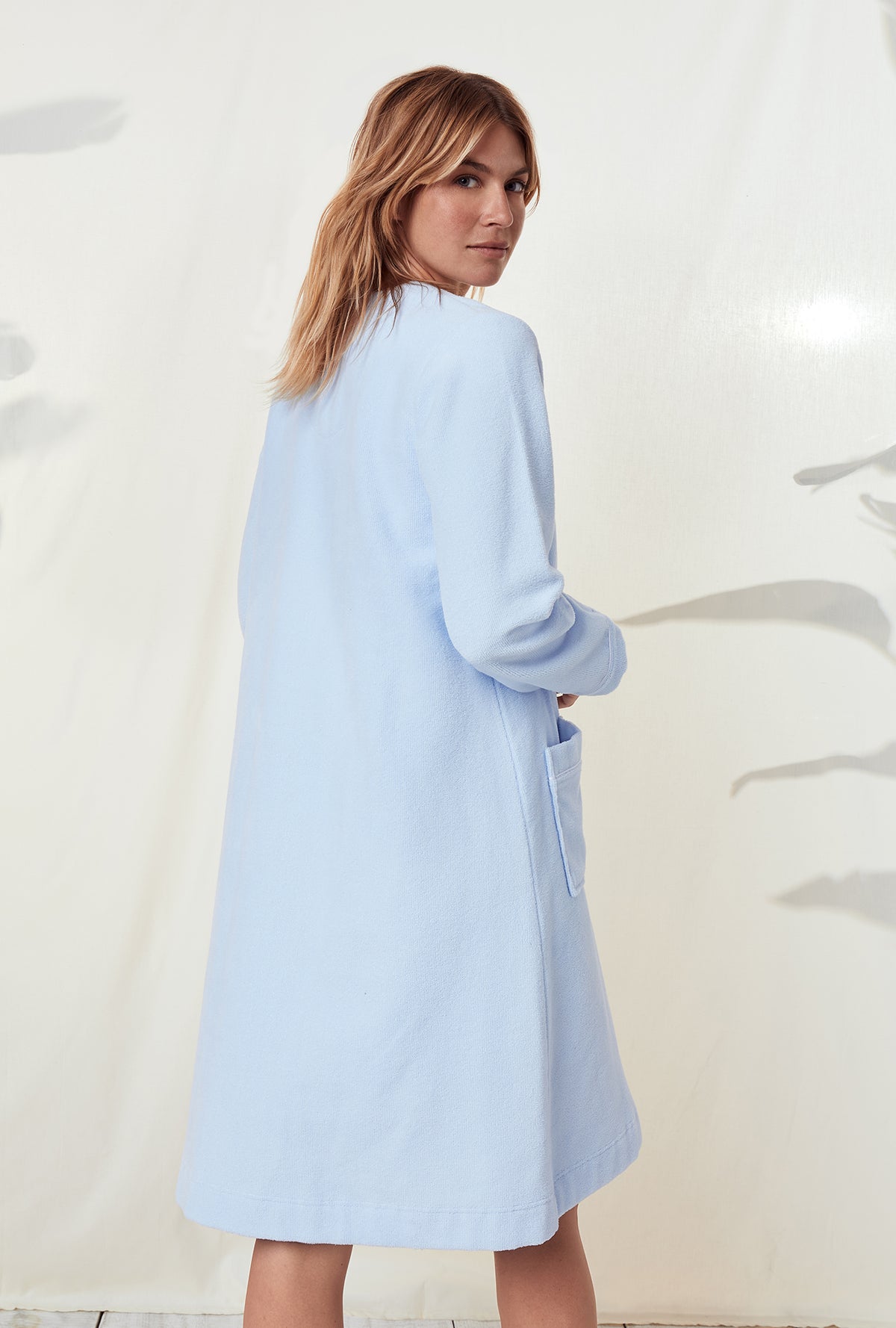 A lady wearing a terry blue long sleeve spa soft zip robe