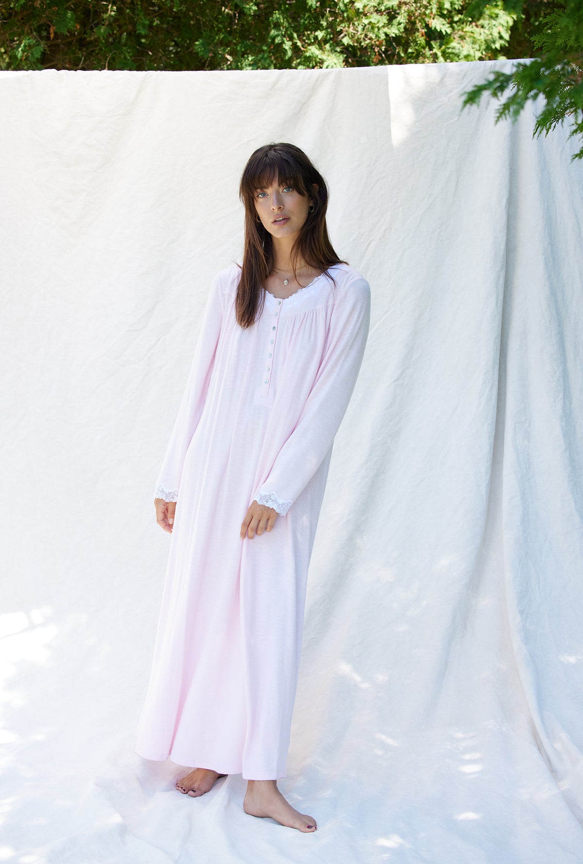 A lady wearing a rose long sleeve long nightgown.