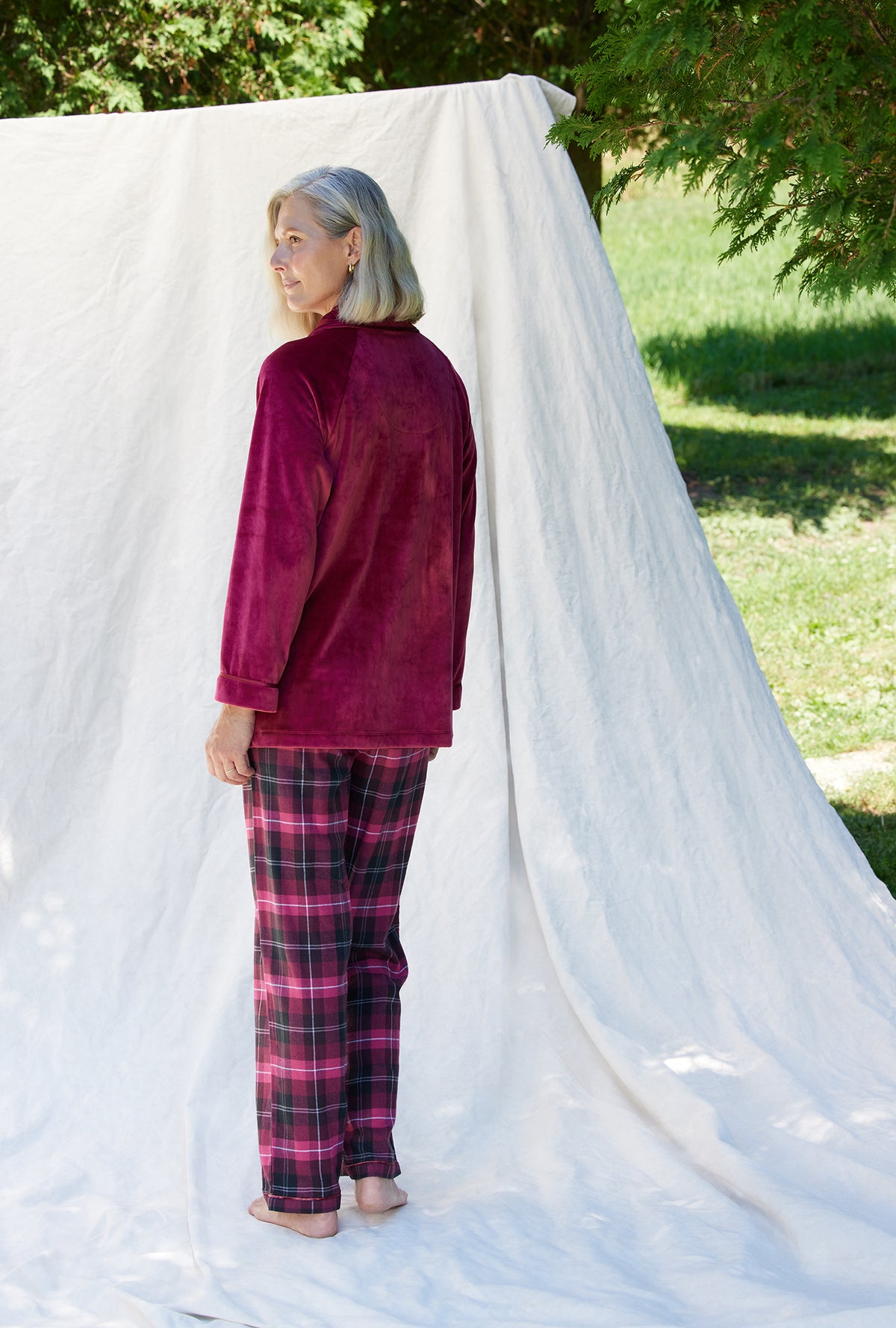 A lady wearing a crimson long sleeve velour short bed jacket.