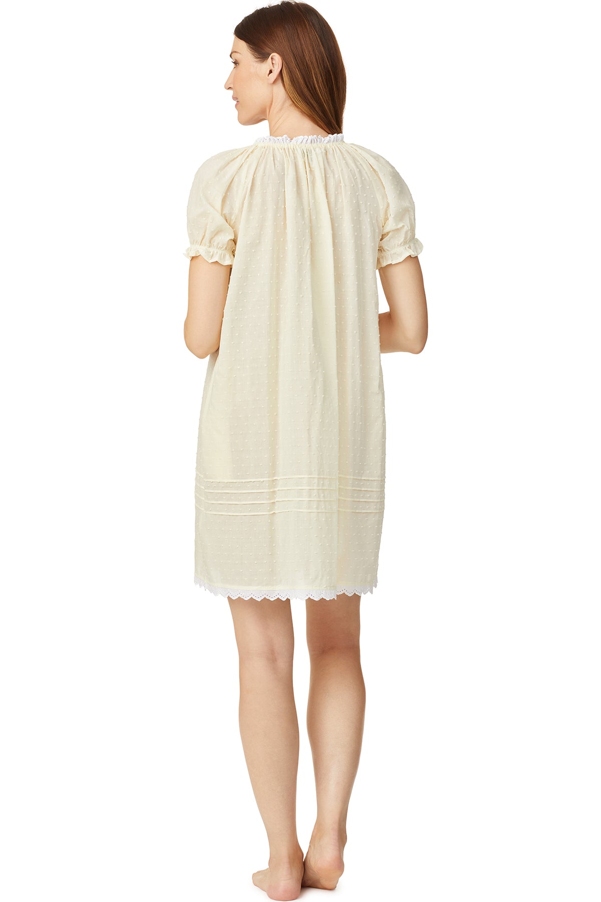 A lady wearing a yellow cap sleeve short nightdress with white dot pattern.
