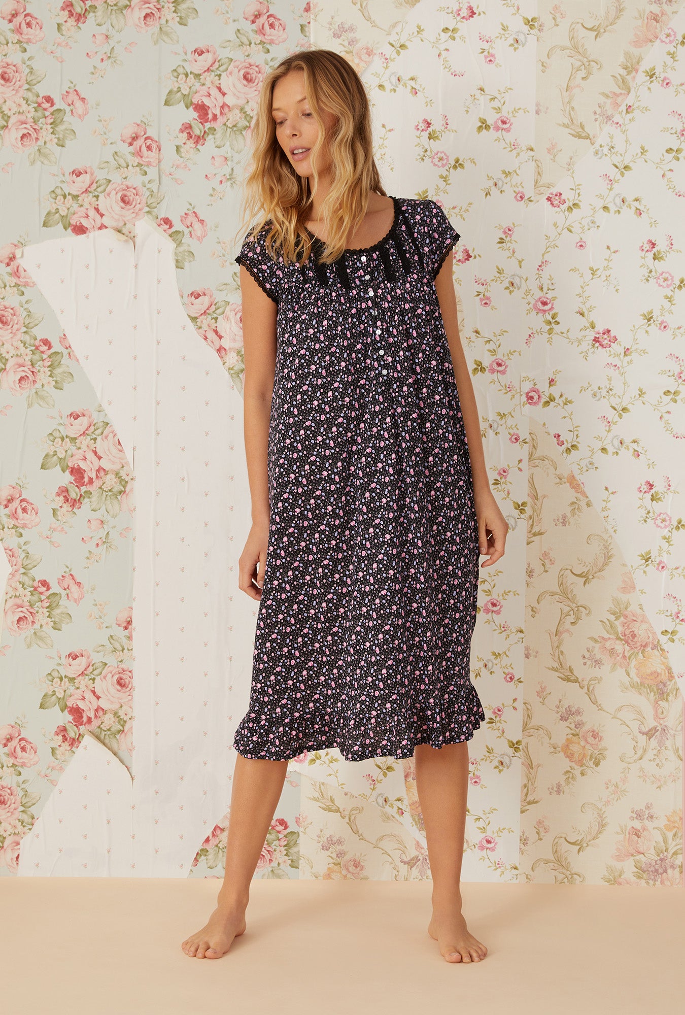 A lady wearing black cap sleeve cotton modal waltz knit nightgown with night blooms print.