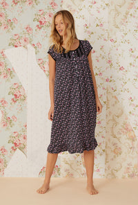 A lady wearing black cap sleeve cotton modal waltz knit nightgown with night blooms print.