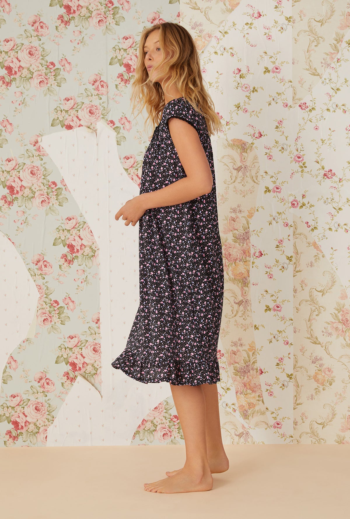 A lady wearing black cap sleeve cotton modal waltz knit nightgown with night blooms print.