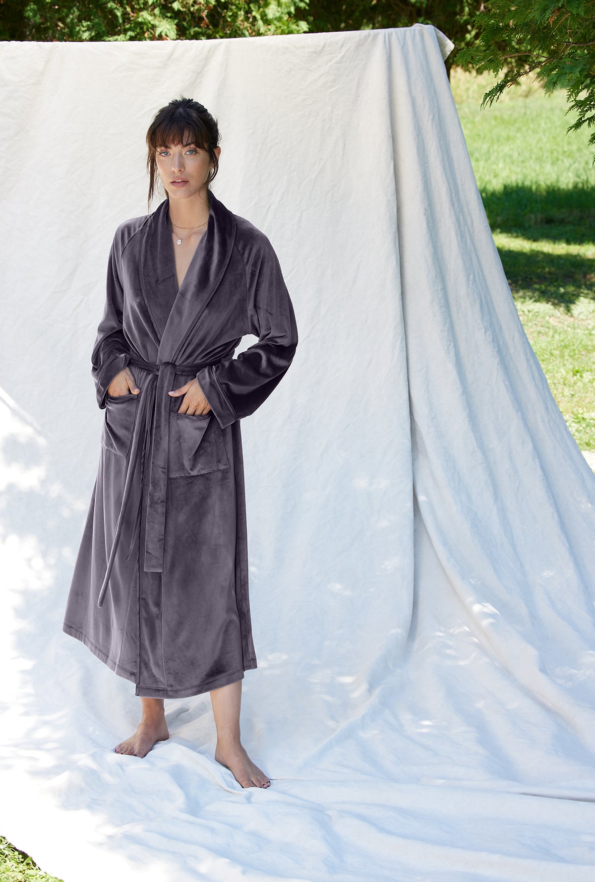 A lady wearing a charcoal grey long sleeve lux velour long wrap robe.