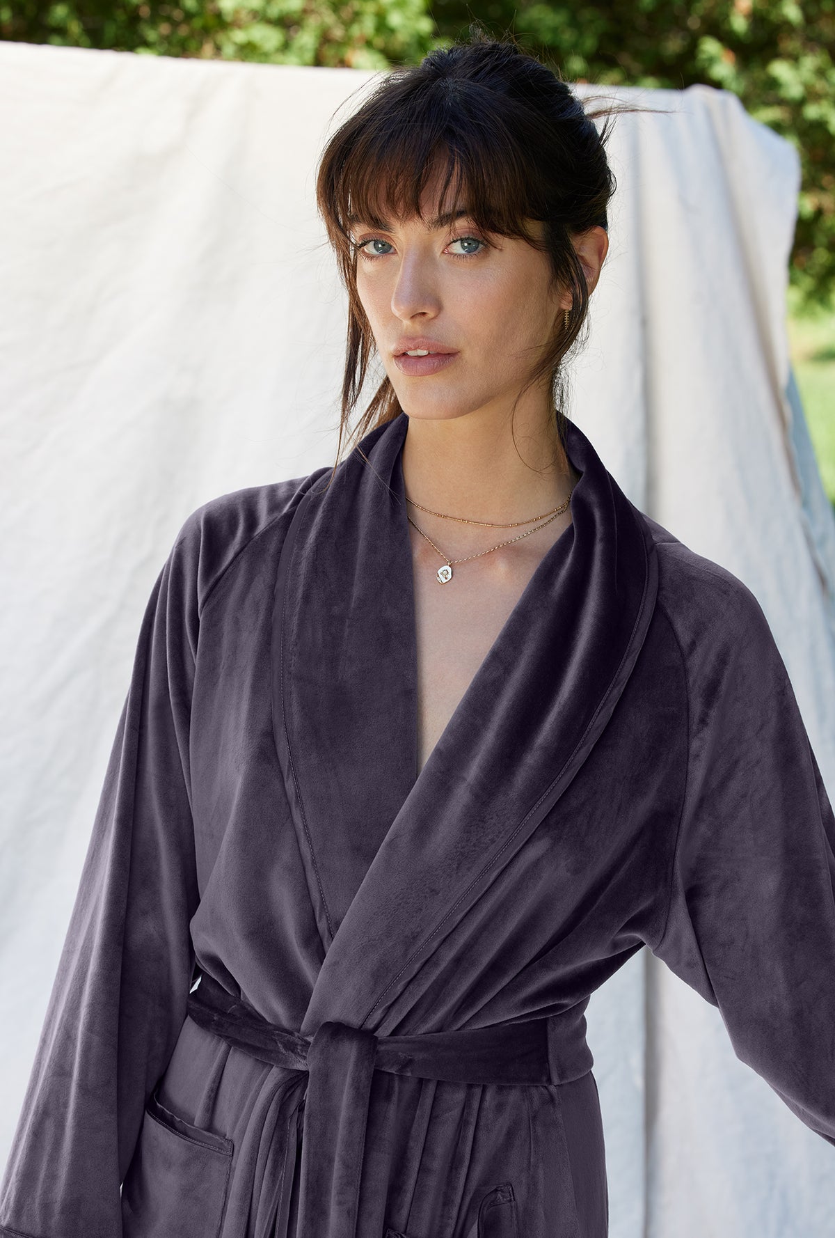 A lady wearing a charcoal grey long sleeve lux velour long wrap robe.