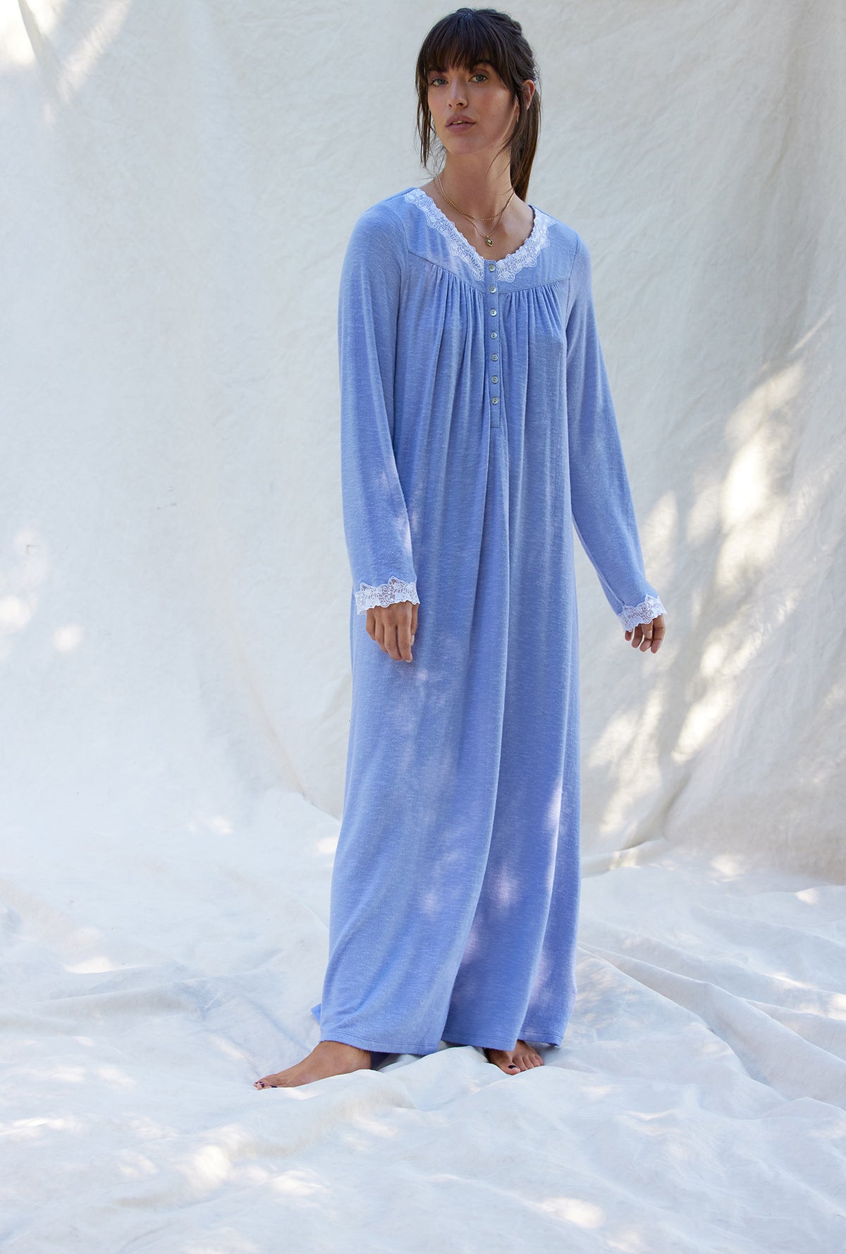 A lady wearing a blueberry long sleeve long nightgown.