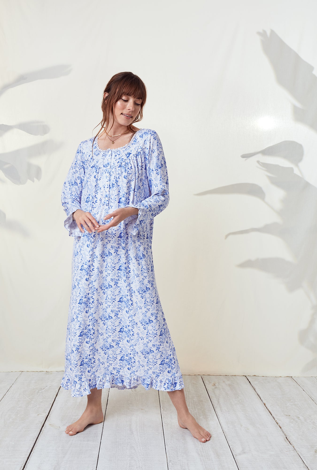 A lady wearing a blue floral long sleeve knit long nightgown..