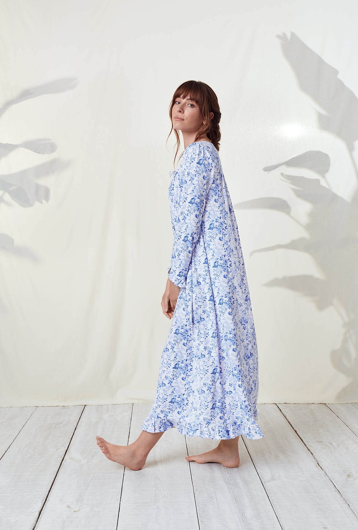 A lady wearing a blue floral long sleeve knit long nightgown..