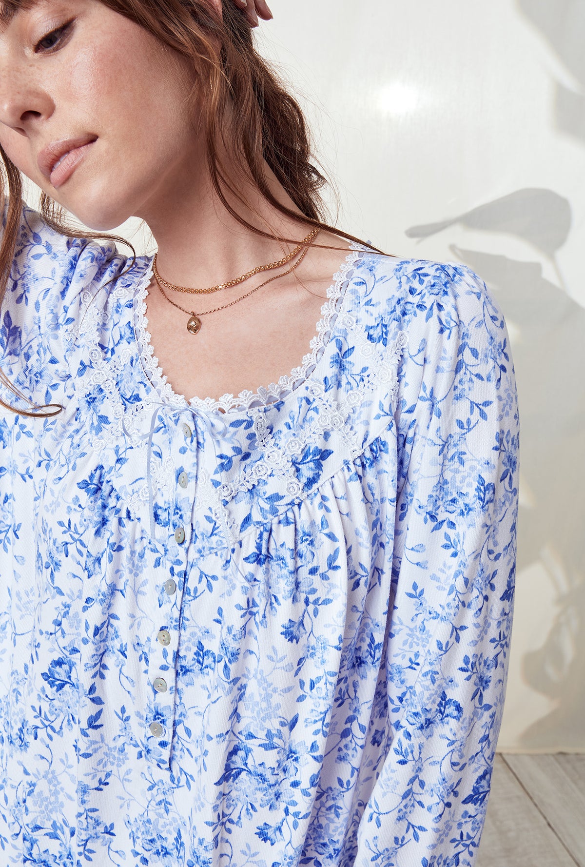 A lady wearing a blue floral long sleeve knit long nightgown..