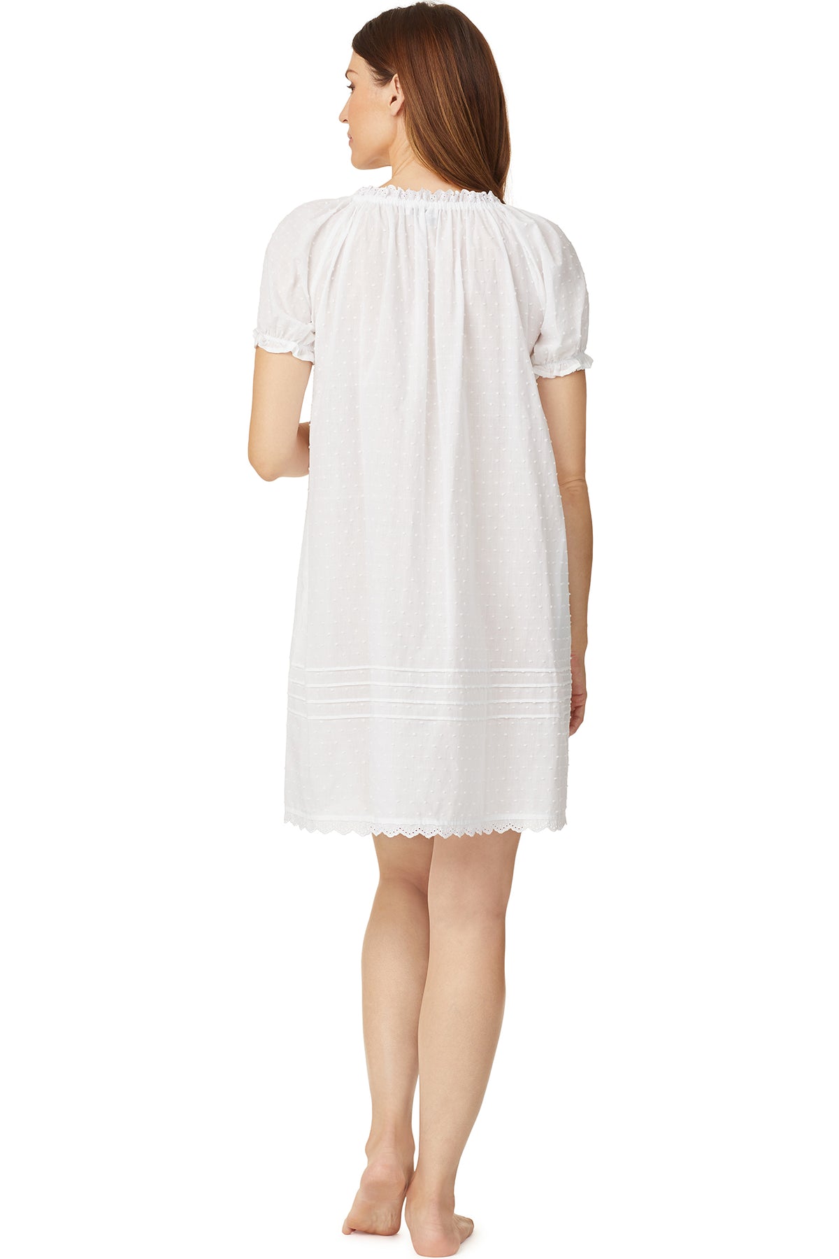 A lady wearing a white cap sleeve short nightdress with white dot pattern.