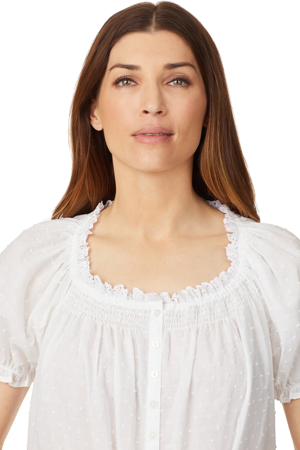 Upper part of a lady wearing a white cap sleeve short nightdress with white dot pattern.