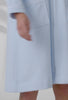 A lady wearing a terry blue long sleeve spa soft zip robe