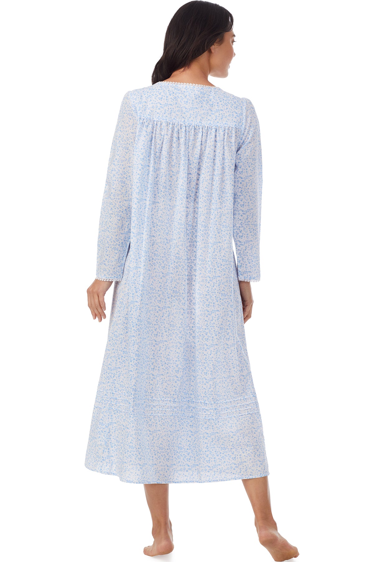 A lady wearing white long sleeve nightgown with blue floral design