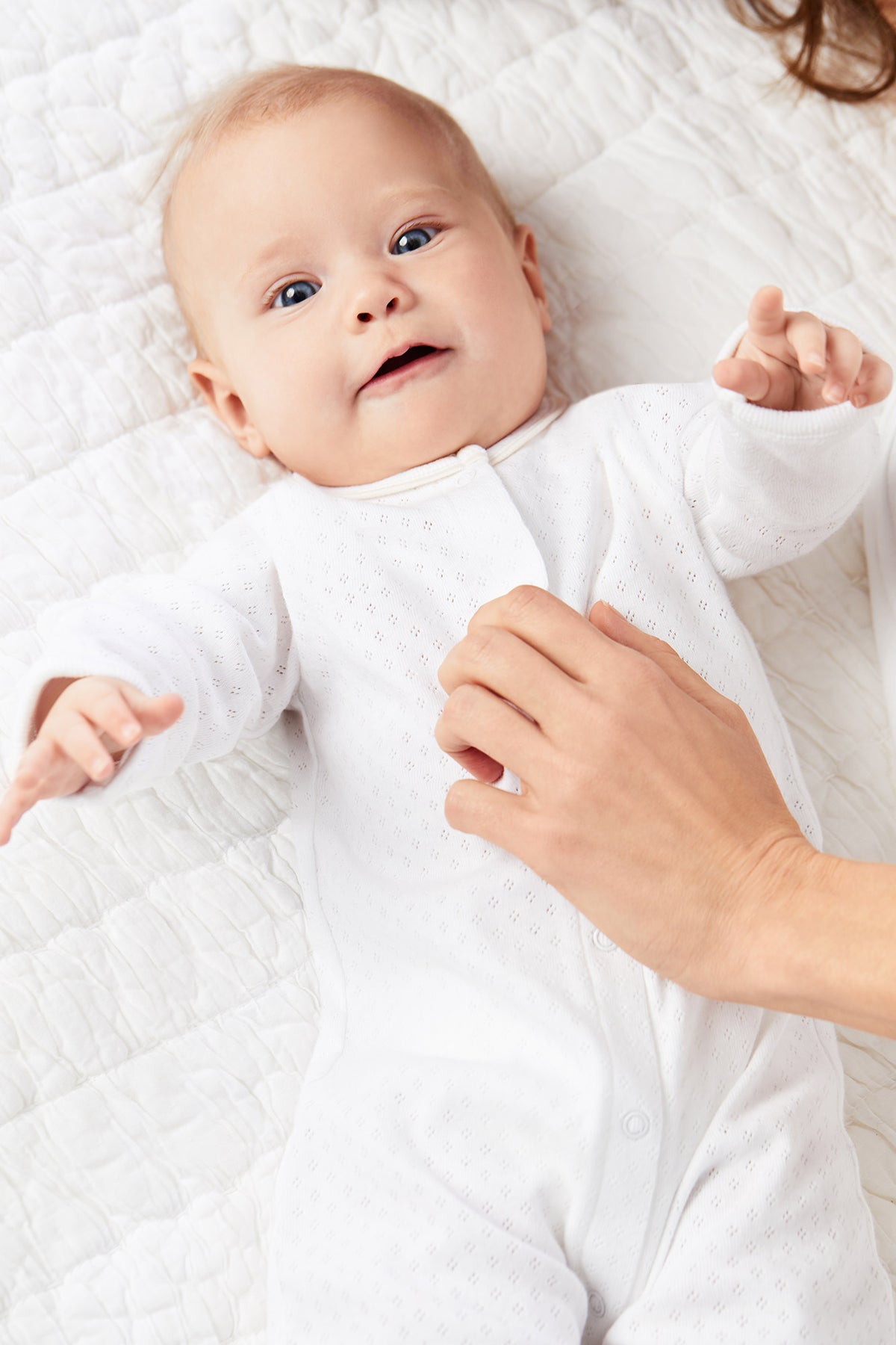 A baby wearing a white dress