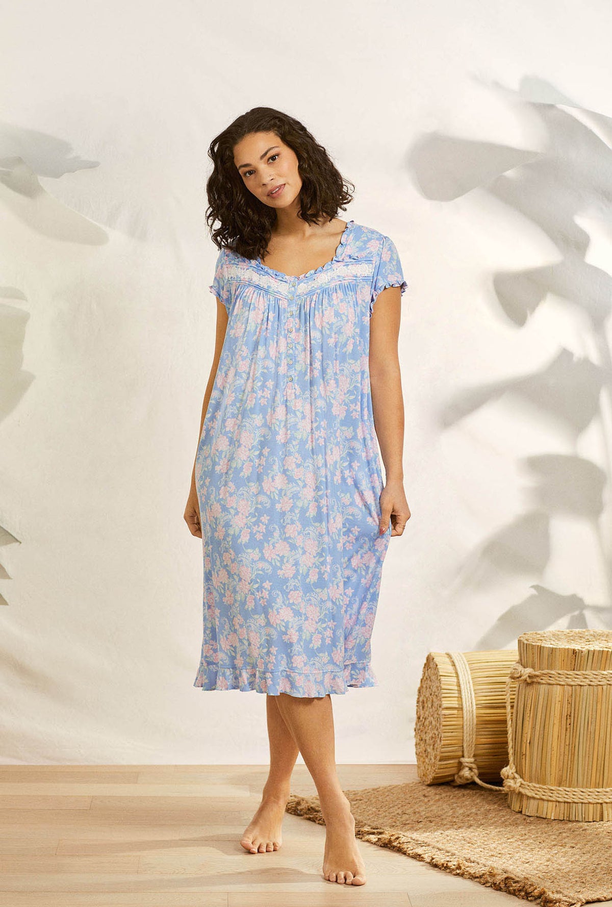 A lady wearing blue cap sleeve waltz plus nightgown with paisley floral print.